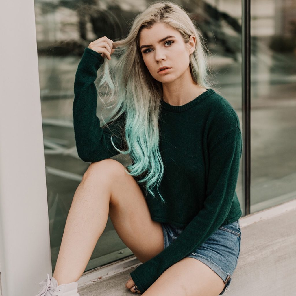 blonde girl with light green ombre sitting outside