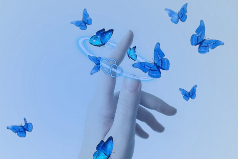 hand reaching out towards blue butterflies