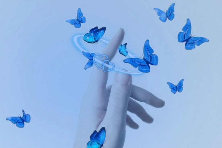 hand reaching out towards blue butterflies