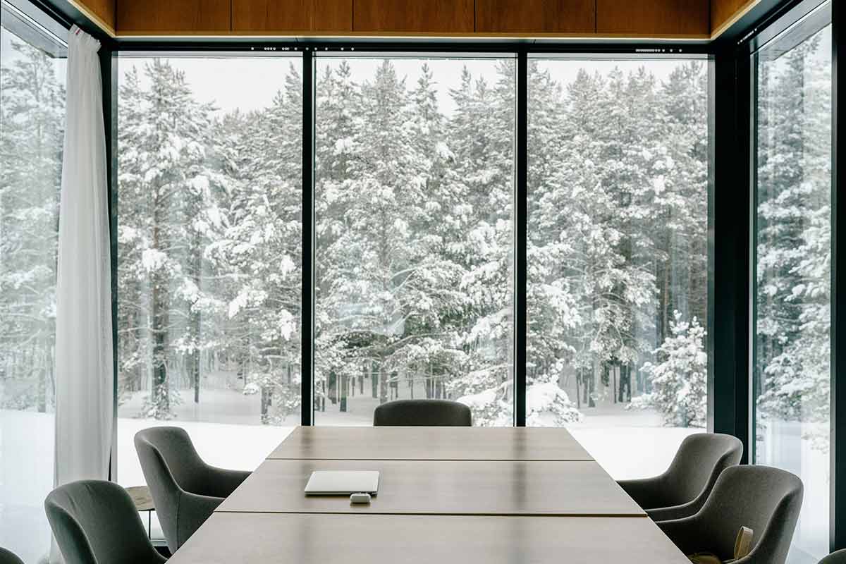 dining room table with curtains open looking with a snowy background