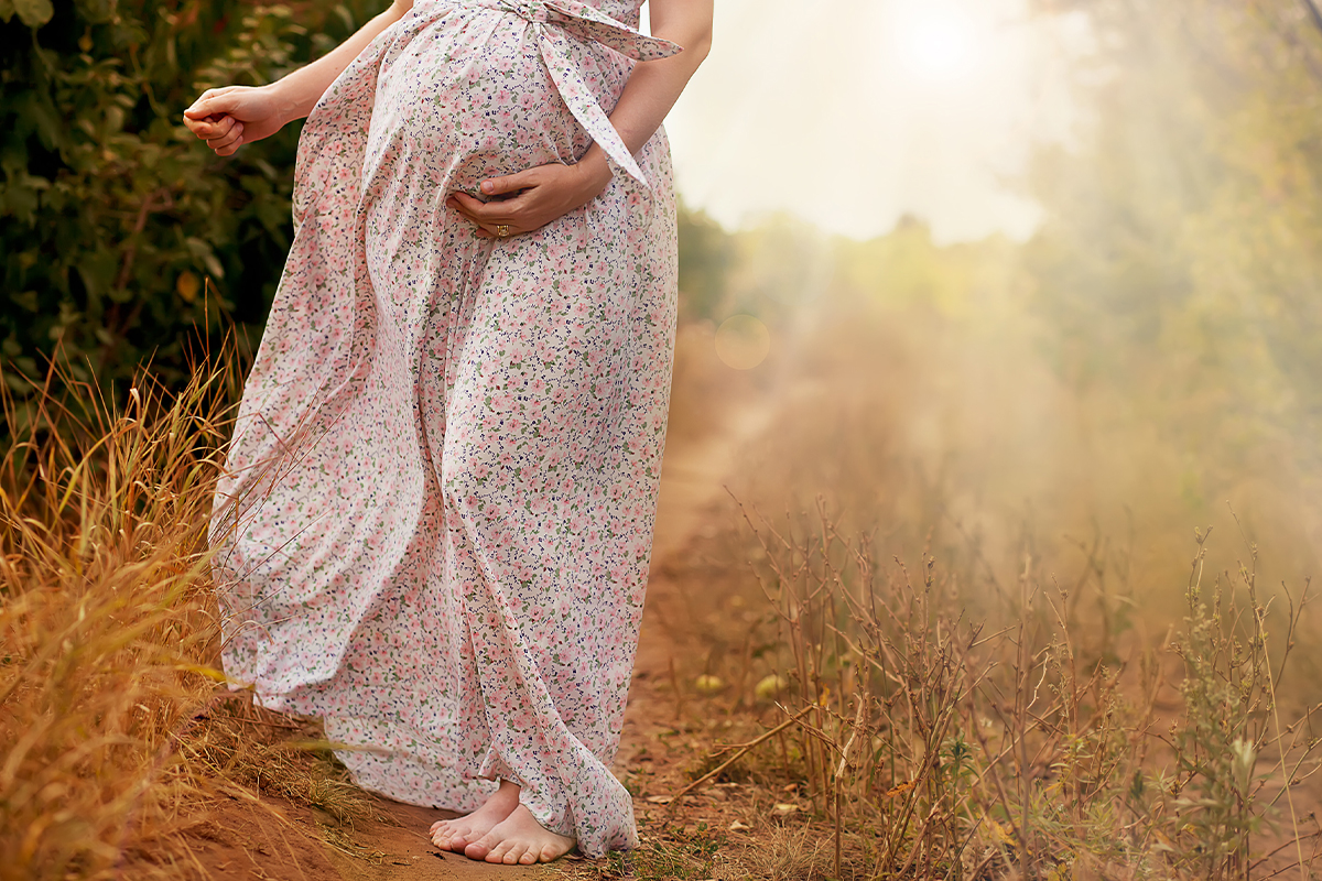 pregnant woman walking on a dirt path