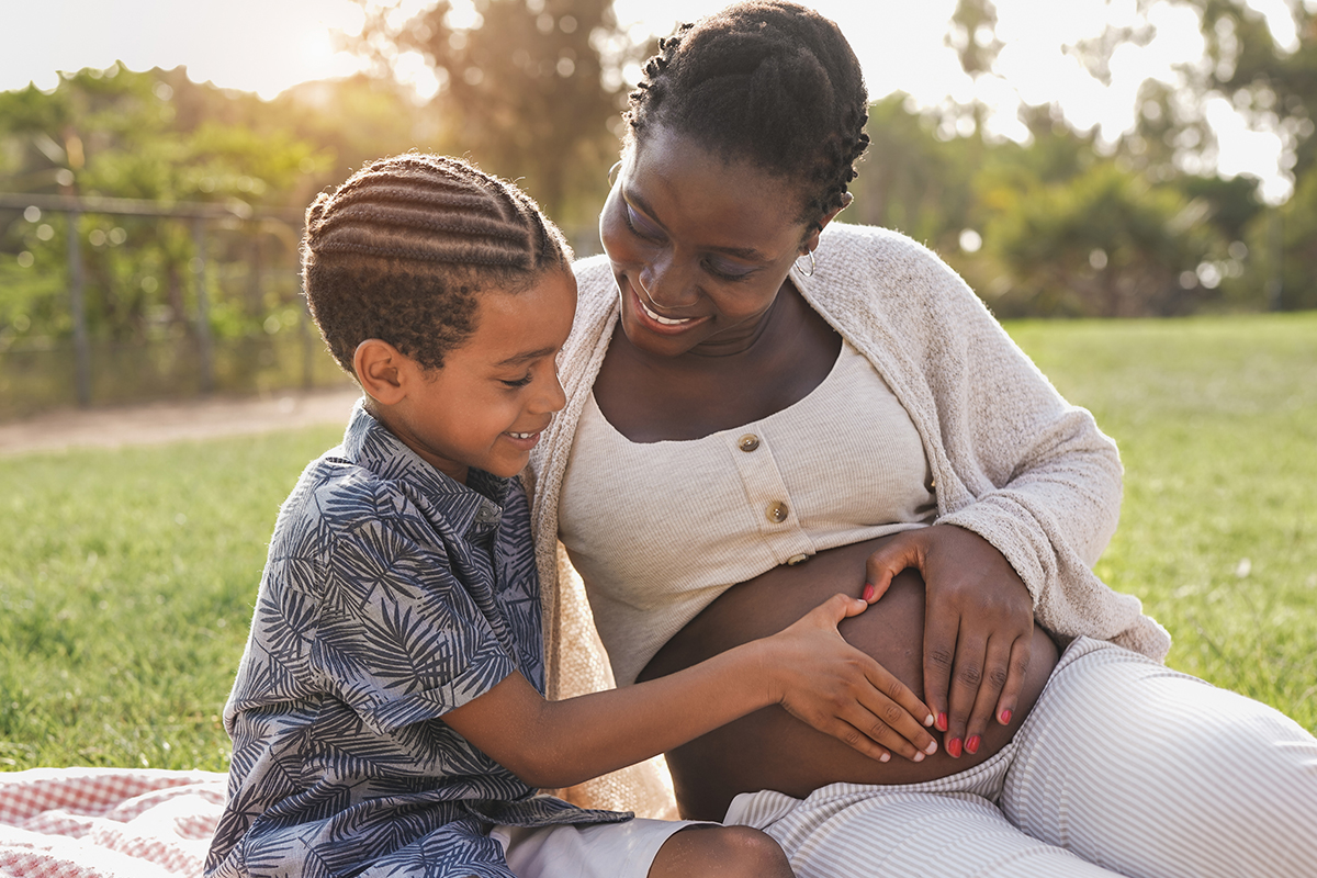 pregnant mother and child touching mothers stomach