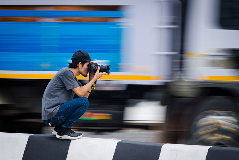 photographer capturing a fast moving blurry truck