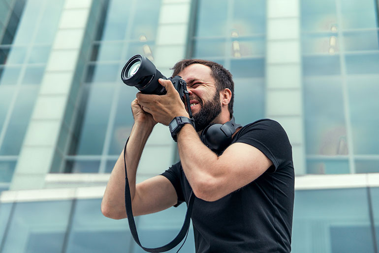 man capturing documentary photography in front of a building