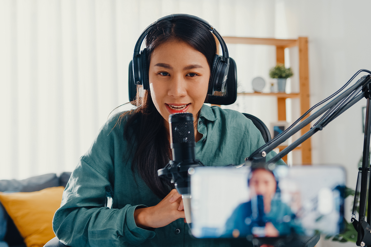 influential podcaster speaking in front of a camera with headphones on
