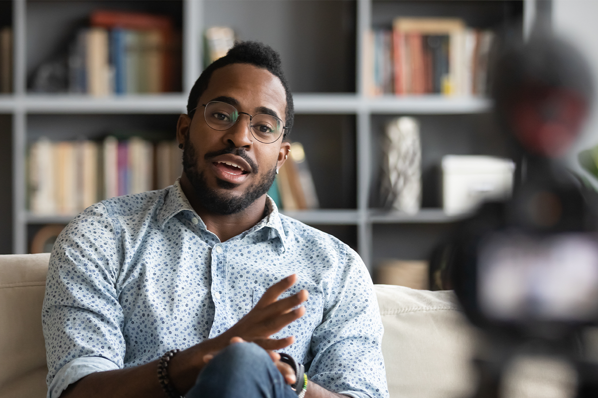 male influencer speaking in front of a camera while in a living room setting