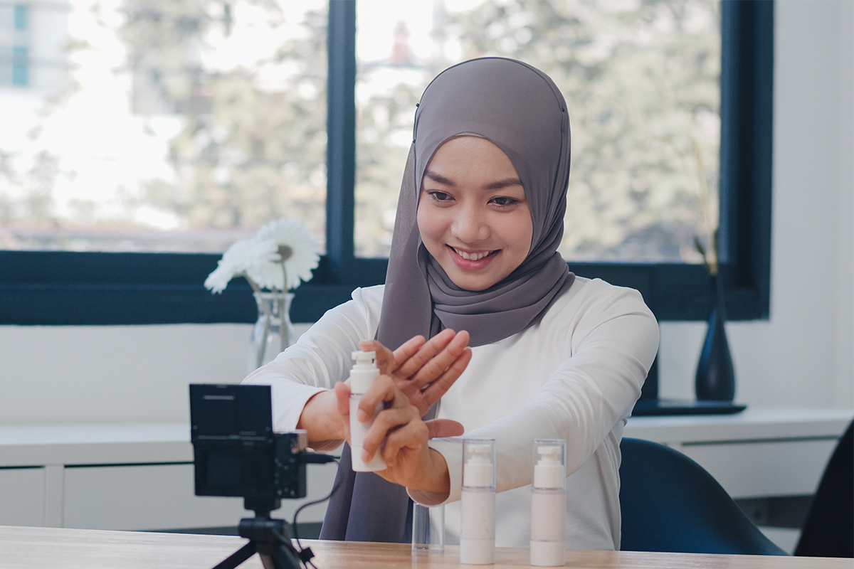 female influencer demonstrating a skincare product in front of a phone