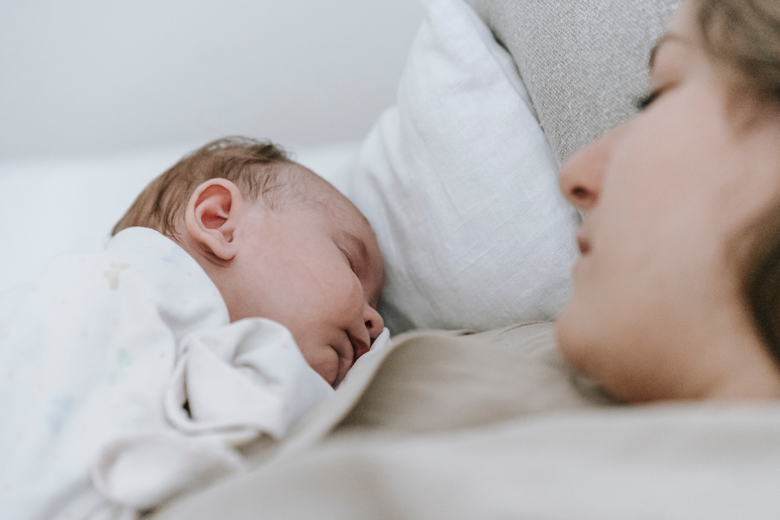 mother bonding with sleeping baby