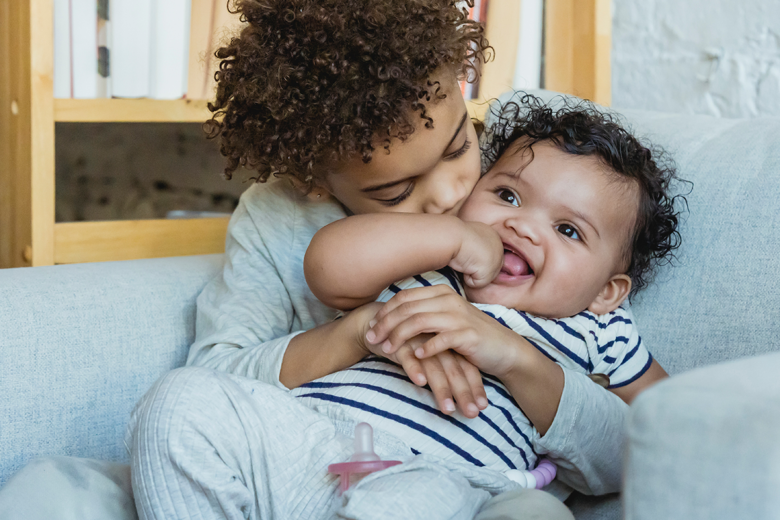 older sibling holding baby