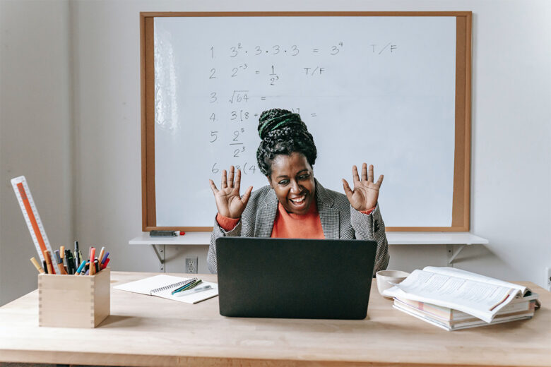 teacher giving virtual lesson at desk