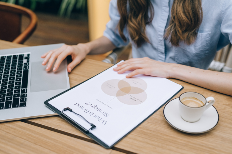 woman at desk with paper saying what is brand strategy