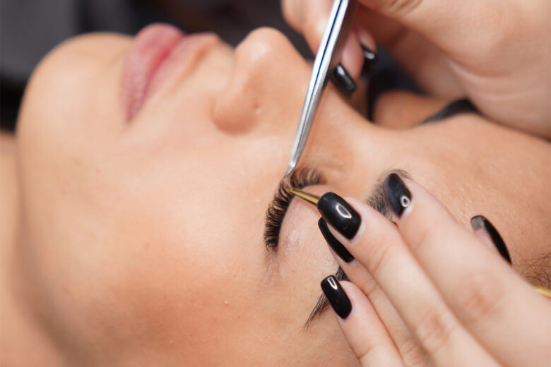 woman getting false eyelashes applied at a salon