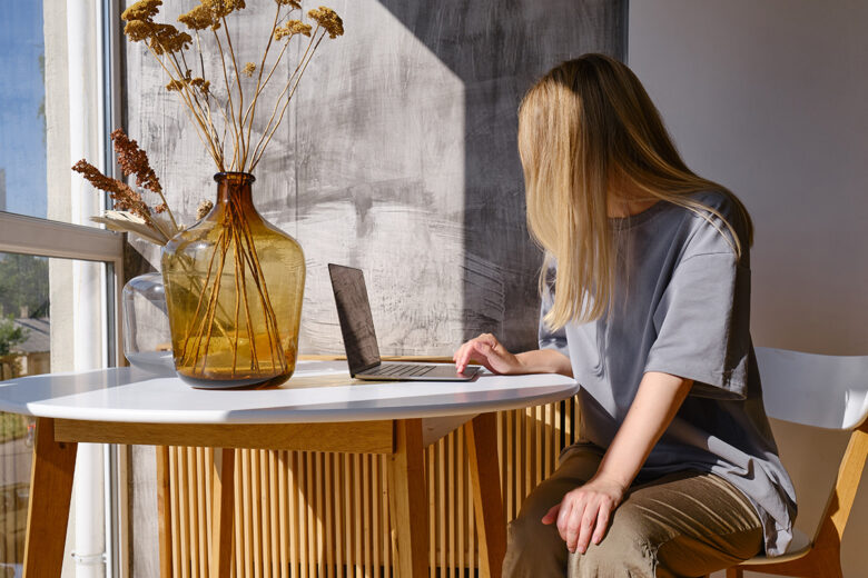 woman sitting at table on laptop during golden hour