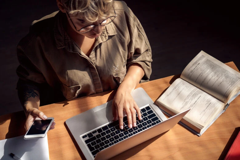 woman at laptop with notebook on desk