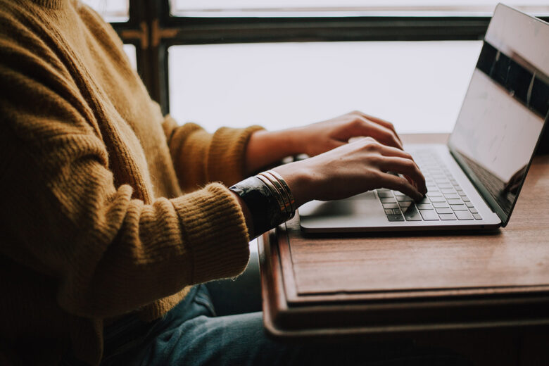 person sitting at laptop in cafe