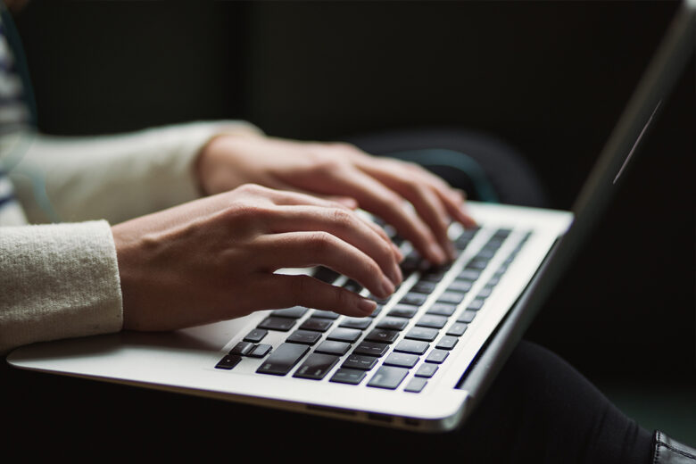 hands on laptop with dark background