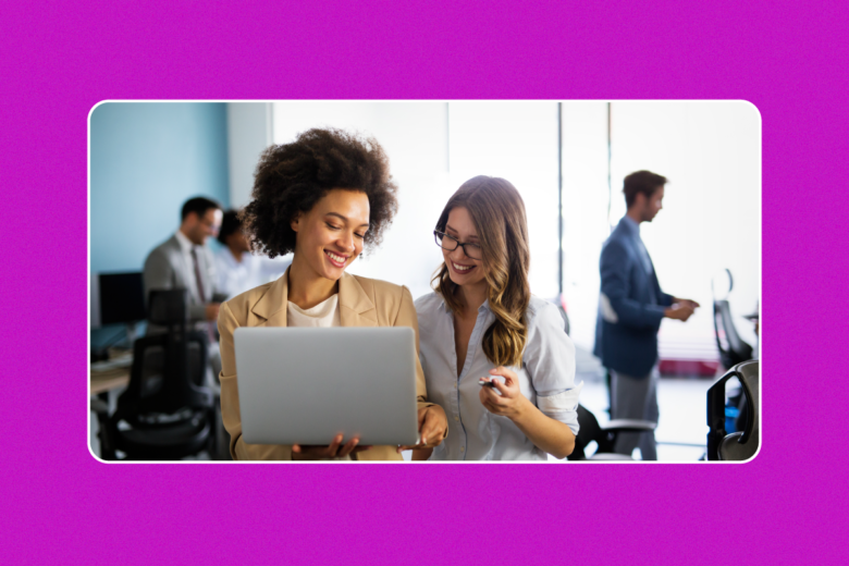 two women looking at a laptop at work